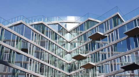 Nyere bygning med facader, der overvejende består af glas